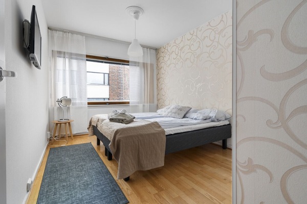 The quality bed (likely a double or two singles, depending on your configuration) is dressed in fresh, crisp linens and comfortable pillows, promising a sound night`s sleep.