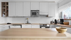 Una cocina moderna con armarios blancos, una isla central y electrodomésticos de acero inoxidable.