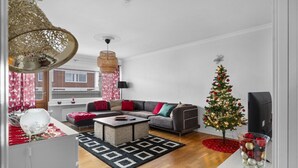 Una sala moderna con un sofá, una mesa de centro y un pequeño árbol de Navidad.
