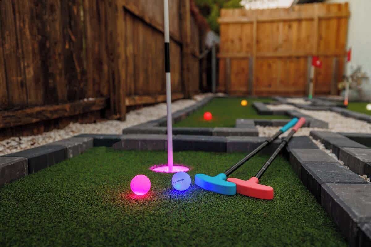 A miniature golf course with a wooden fence and artificial grass.