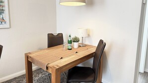 Een eettafel met stoelen, een lamp, een fles en een kleine plant.