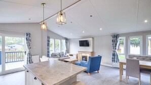 A spacious living area with a kitchen island, seating, and a fireplace. - Host Stay Beryl Lodge (York)
