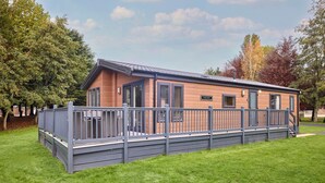 A modern, single-story building with a flat roof, large windows, and a covered outdoor area with a railing. - Host Stay Beryl Lodge (York)