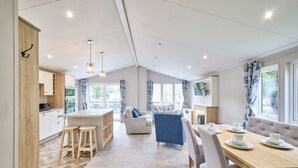 A modern kitchen with a central island, bar stools, and a dining area with a wooden table and chairs. - Host Stay Beryl Lodge (York)