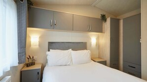 Ein Schlafzimmer mit Bett, Nachttischen und einem Kleiderschrank.
