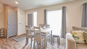 Ein kompakter Wohnbereich mit Essplatz, Küchenzeile und Sofa.
