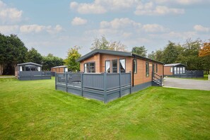 Ein Wohnmobil mit umzäunter Terrasse und kleiner Veranda.