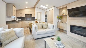 A modern living room with a sofa, coffee table, and fireplace. - Host Stay Wag Tail Lodge (York)