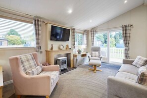 A cozy living room with a fireplace, comfortable seating, and a television. - Host Stay Kinship Lodge (York)