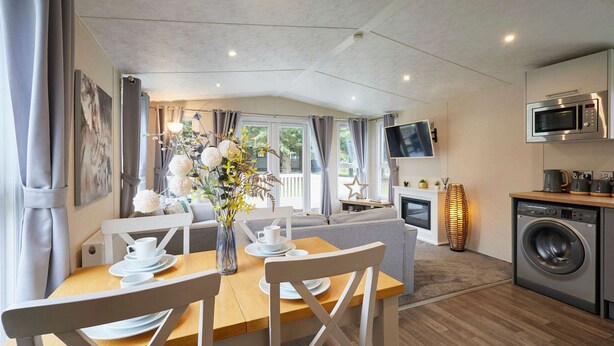 Eine moderne Küche mit Mikrowelle, Waschmaschine und Flachbildfernseher. Ein Essbereich mit Tisch und Stühlen sowie eine Wohnbereich mit Sofa und Kamin.
