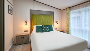 A hotel room with a large bed, two bedside tables, a green headboard, and a window with sheer curtains. - Host Stay Gleneagles Lodge (York)