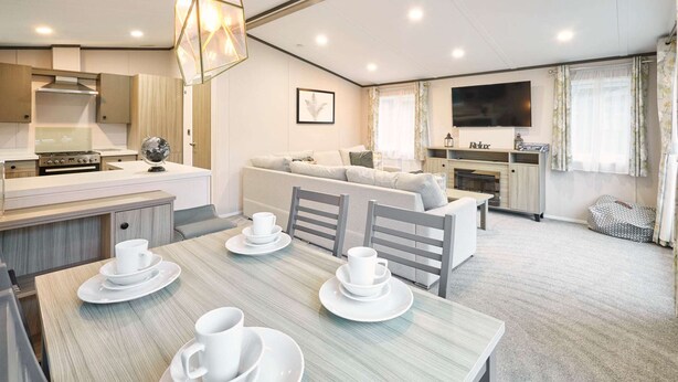 A modern, well-lit living space with a dining area, kitchen, and seating area. - Host Stay Gleneagles Lodge (York)