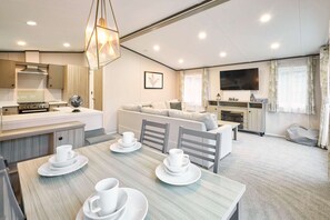 Un espacio habitable moderno y bien iluminado con comedor, cocina y zona de estar.