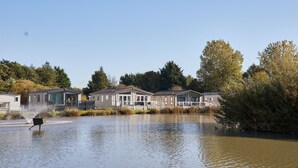 A residential area with houses along a water body, surrounded by trees. - Host Stay Hawthorne Villa (York)