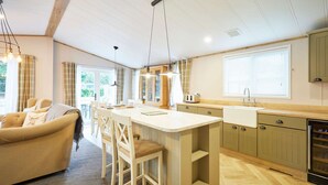 A modern kitchen with a central island, wooden cabinets, and pendant lighting. - Host Stay Hawthorne Villa (York)