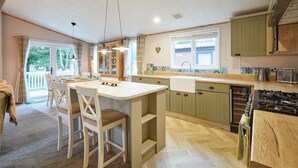 Cucina spaziosa con isola centrale, mobili in legno e un'ampia finestra che lascia entrare molta luce naturale.