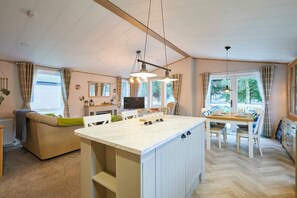 Una habitación acogedora y bien iluminada con una isla grande, un sofá y un comedor.