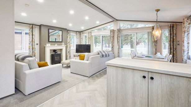 Una sala moderna con un sofá, un televisor y un comedor con una mesa y sillas.