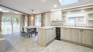 Una cocina moderna con comedor, ventanas amplias y un tragaluz.
