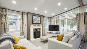 Una sala de estar con chimenea, sofá y televisión.