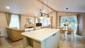 Amplia sala de estar con sofá, mesa de comedor y una isla de cocina.