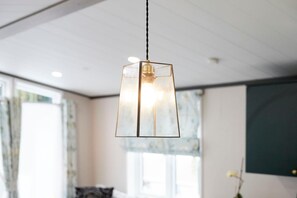 A modern room with a hanging pendant light, large windows, and a view of the outdoors. - Host Stay Teejay s Lodge (York)
