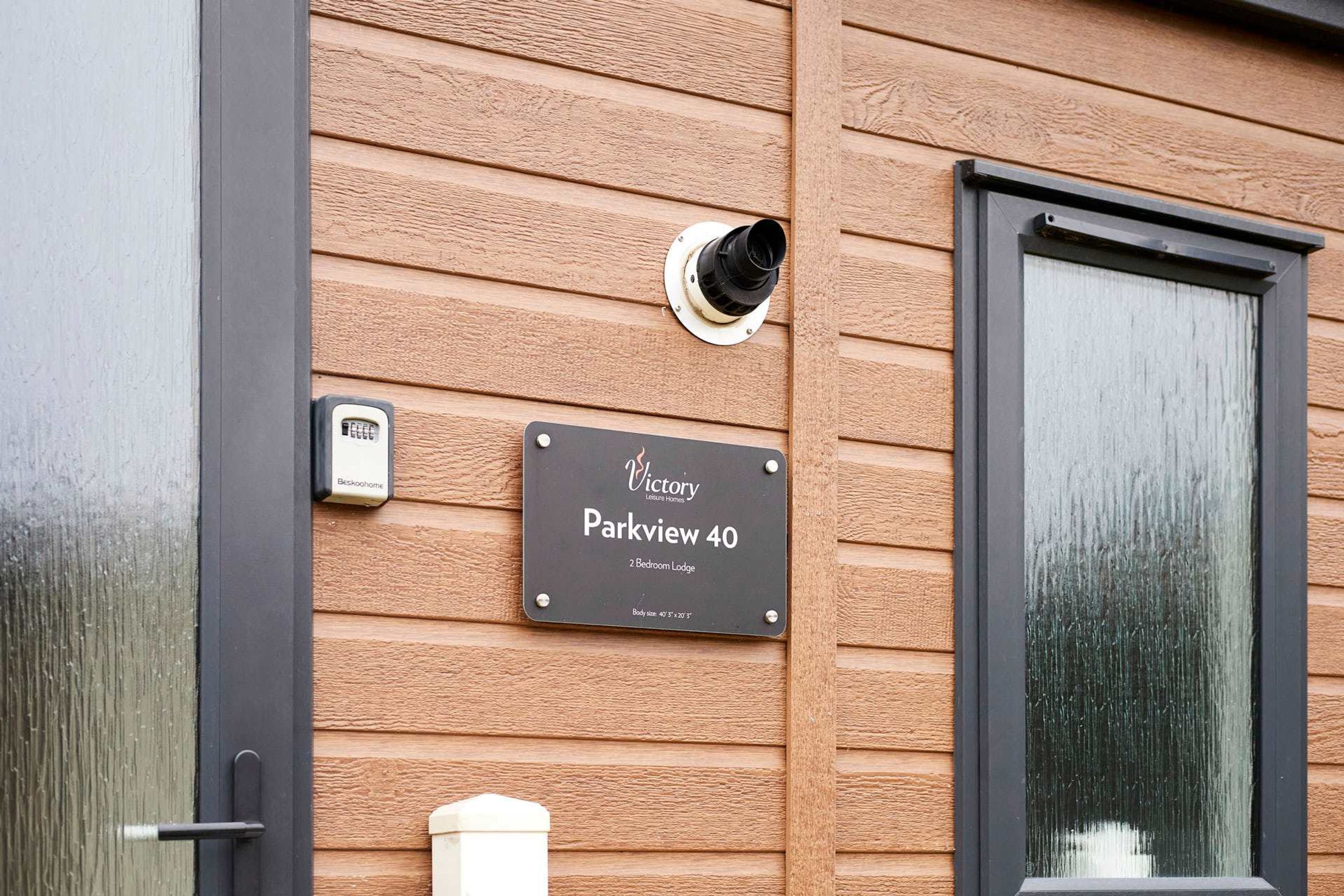 Pared exterior de madera con una placa que dice 