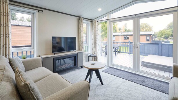 A modern living room with a sofa, a TV, and a round table. - Host Stay Field View Lodge (York)