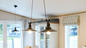 A dining area with a table set for two, two pendant lights hanging above, and a window with a view of the outdoors. - Host Stay Water s Edge Lodge (York)
