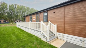 A single-story wooden building with a white porch and steps leading to a door. - Host Stay Water s Edge Lodge (York)