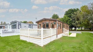 A row of mobile homes with white railings and a grassy lawn. - Host Stay Brooksbank Lodge (York)