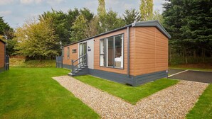 A single-story mobile home with a small porch and a staircase leading to the entrance. - Host Stay 23 Sandy Lane (York)