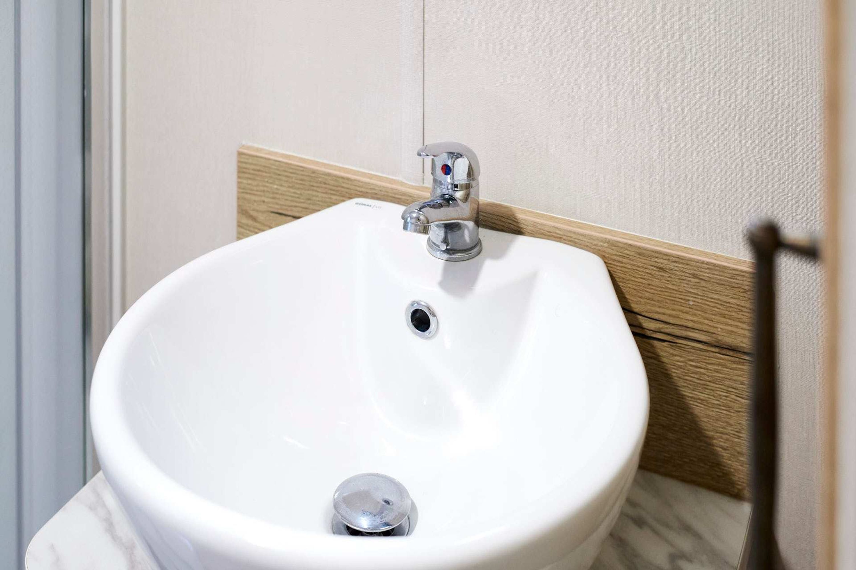 A white pedestal sink with a chrome faucet in a bathroom.