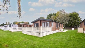 A row of mobile homes with white railings and a grassy lawn. - Host Stay Barakah Lodge (York)