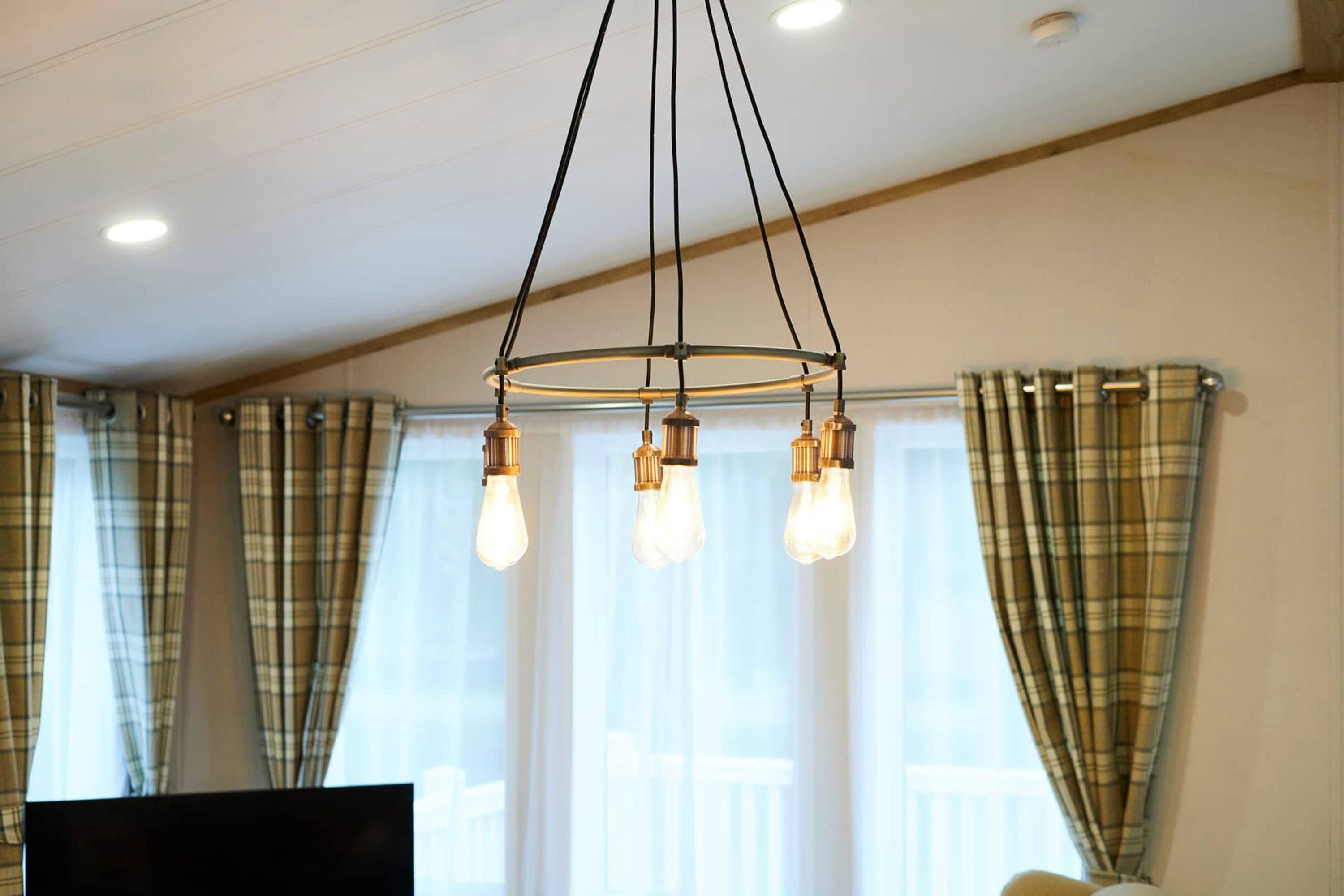Une pièce dotée d’un luminaire au plafond et d’un téléviseur à écran plat.