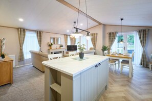 A spacious living area with a central island, a dining table, and a sofa. - Host Stay Barakah Lodge (York)