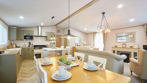Une cuisine moderne avec un coin repas, un plancher en bois et un espace salon confortable.