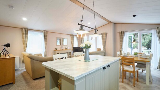 Une cuisine moderne dotée d’un îlot central, d’une table à manger en bois et de chaises.