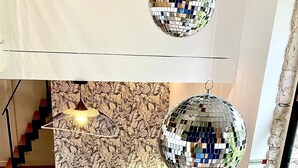 A modern living room with a sofa, a small table, and two disco balls.