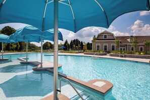 A swimming pool with blue umbrellas, a clear sky, and a building in the background. - Spacious 4 bed, 3.5 bath townhome located in Ocean View Beach Club; community pool, fitness center, shuttle, playground, sauna, Free WIFI (Ocean View)