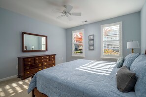 A bedroom with a bed, dresser, and two windows with blinds. - Spacious 4 bed, 3.5 bath townhome located in Ocean View Beach Club; community pool, fitness center, shuttle, playground, sauna, Free WIFI (Ocean View)