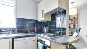 Una cocina compacta con lavavajillas, estufa y horno pequeño.