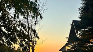 Un chemin menant à une maison d’où l’on peut admirer le coucher de soleil sur une étendue d’eau.