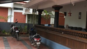 A covered parking area with two motorcycles parked. -  Kulture KonnectT North Cliff" (Varkala)