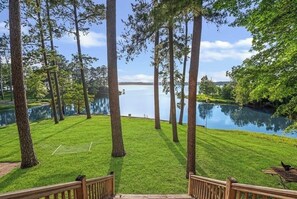 A well-maintained lawn with a wooden deck and a view of a lake. - Terrific cabin on Lake Sam Rayburn (Broaddus)