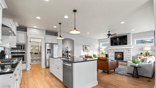 A modern kitchen with white cabinetry, stainless steel appliances, and a central island. - Modern Family Home | Sauna, Fire Pit, Swings & Access to Pools & Parks (Kuna)