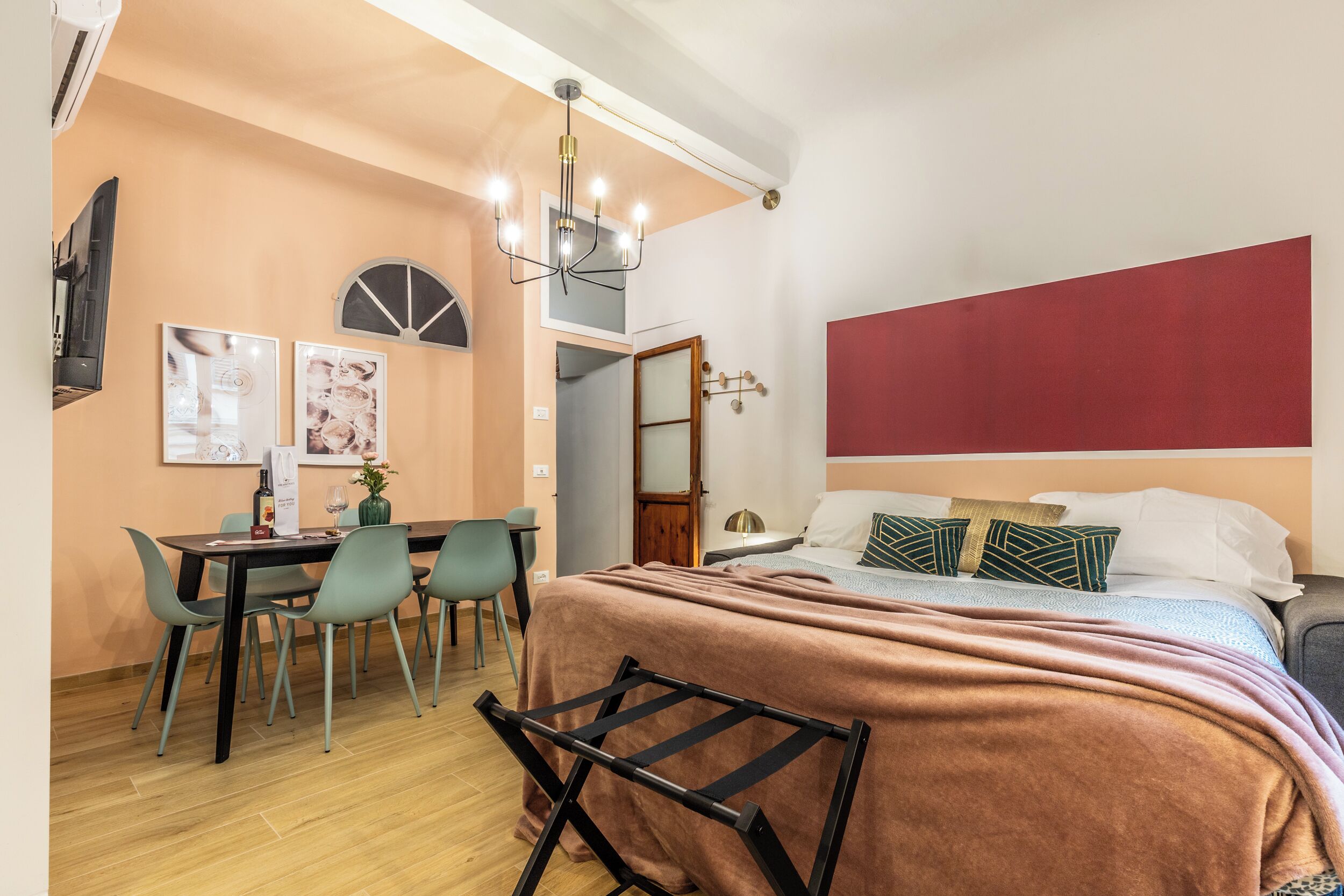 A bedroom with a bed, bedside table, and a desk with chairs.