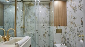 A modern bathroom with a glass-enclosed shower, marble walls, and a wooden cabinet. - New Apartment Center of Paris Le Marais (Paris)
