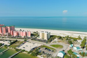 Ein Hotel in Küstennähe mit mehreren Gebäuden, einem Parkplatz und einem Strand.