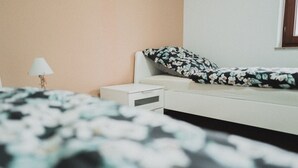 A bedroom with a bed, a nightstand, and a lamp.